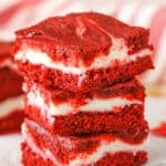 Three Red Velvet Cheesecake Swirl Brownies stacked on a white napkin