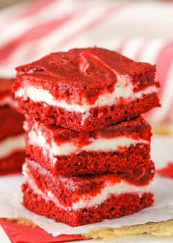 Three Red Velvet Cheesecake Swirl Brownies stacked on a white napkin