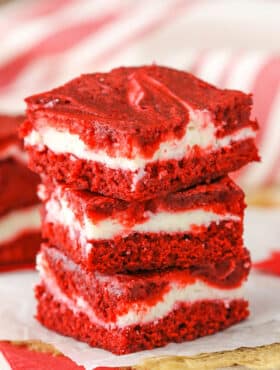 Three Red Velvet Cheesecake Swirl Brownies stacked on a white napkin