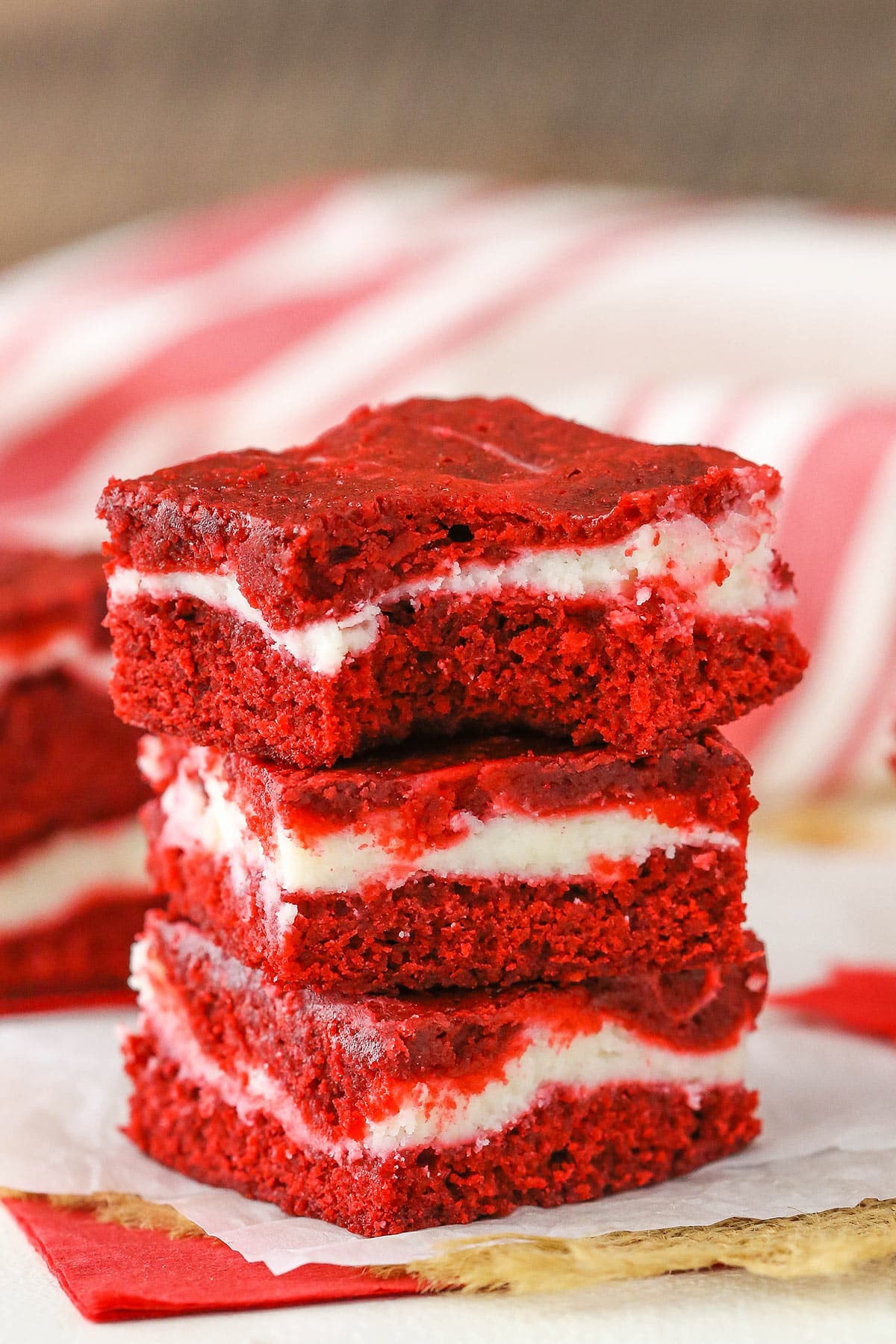 Three Red Velvet Cheesecake Swirl Brownies stacked on a white napkin