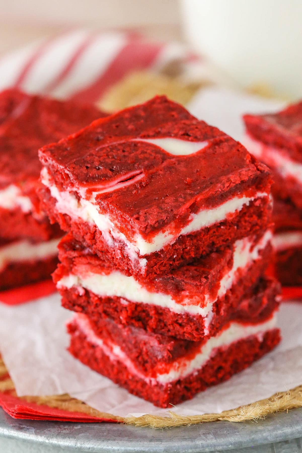 Three Red Velvet Cheesecake Swirl Brownies stacked on a white napkin