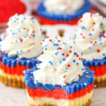 A Red White and Blue Mini Cheesecake with a bite removed on a white plate