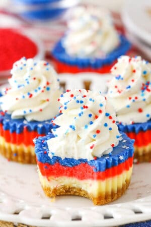 A Red White and Blue Mini Cheesecake with a bite removed on a white plate