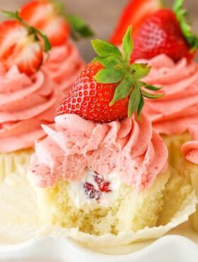 A Strawberries and Cream Cupcake with a bite removed