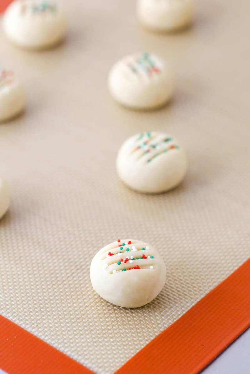 Unbaked whipped shortbread cookies on a baking sheet