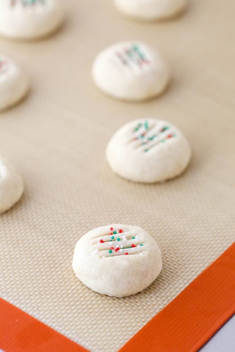 Baked whipped shortbread cookies on a baking sheet