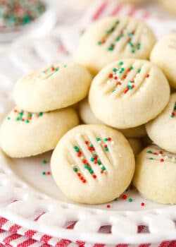 A pile of whipped shortbread cookies on a white plate