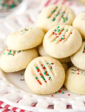 A pile of whipped shortbread cookies on a white plate