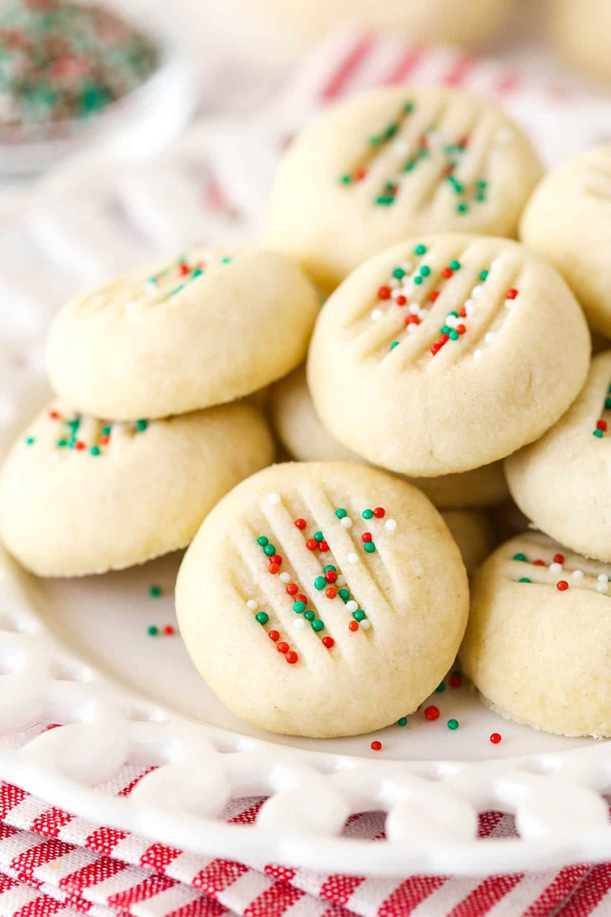 A pile of whipped shortbread cookies on a white plate