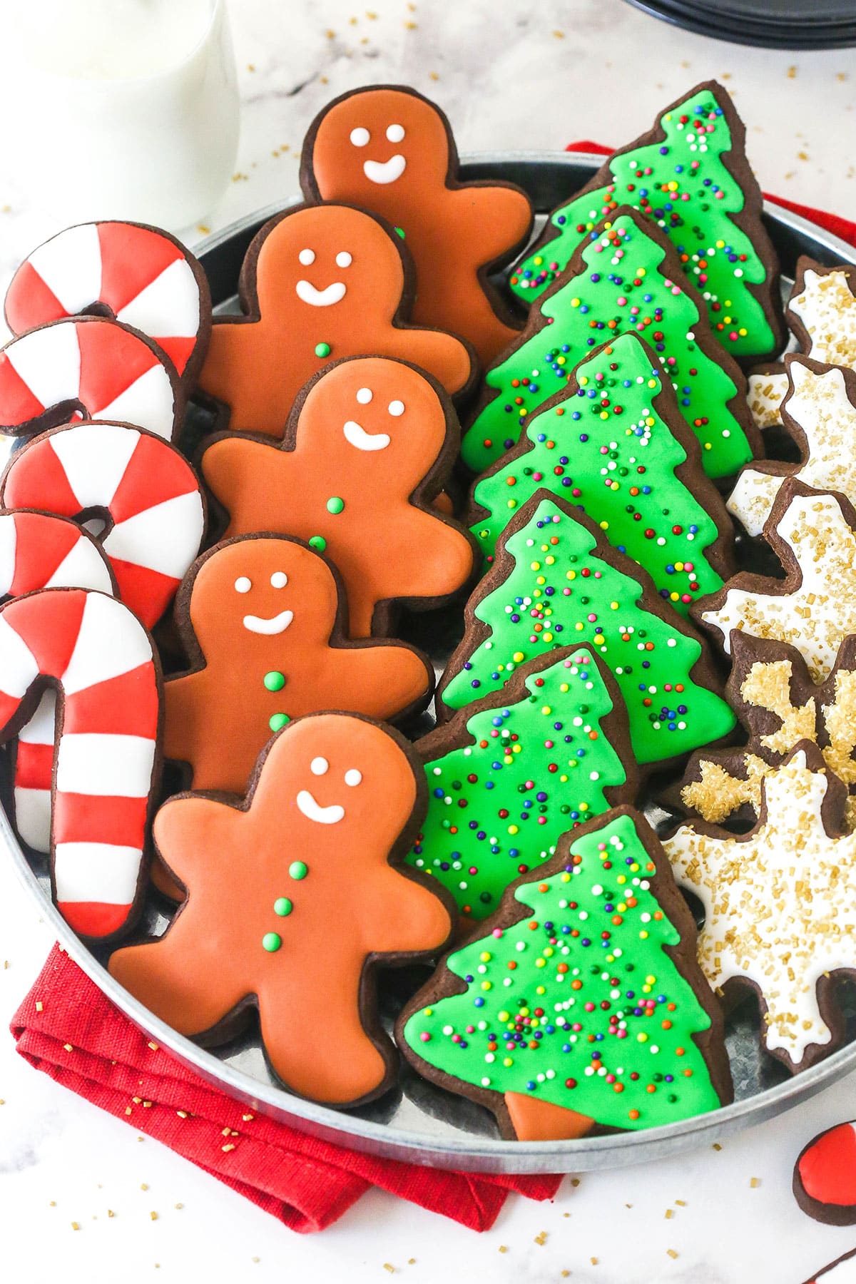 overhead view of chocolate cut out cookies decorated for Christmas on a tray