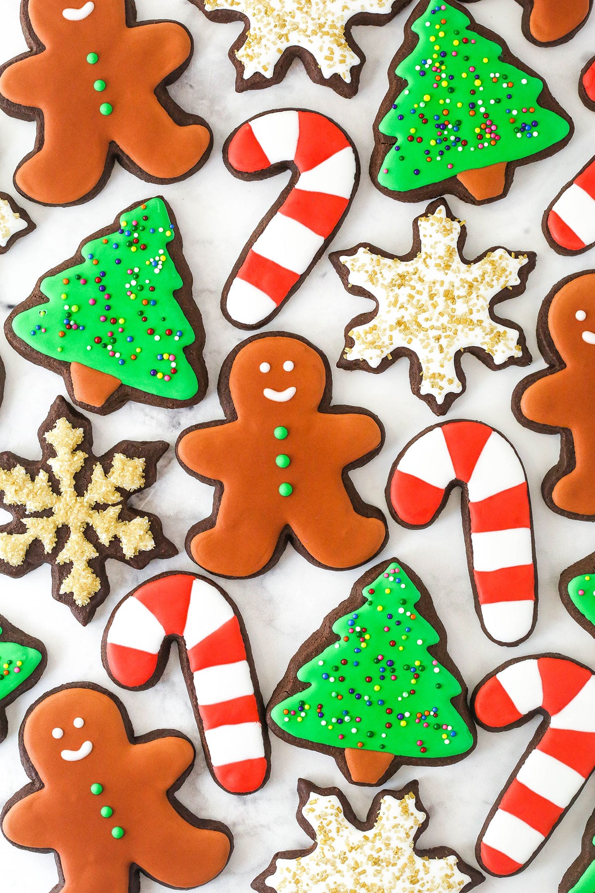 overhead view of chocolate cut out cookies decorated for Christmas