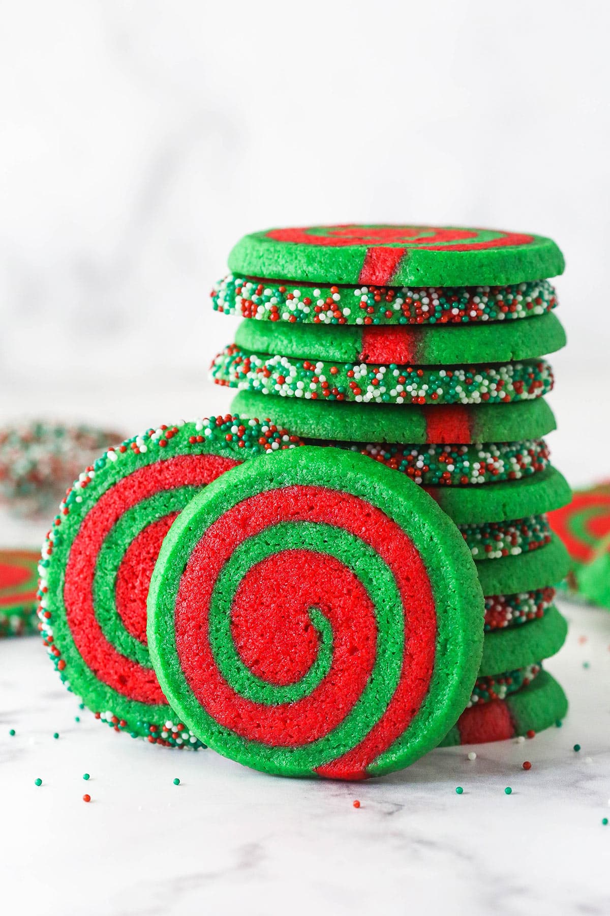 A stack of pinwheel Christmas cookies with two on their sides leaning against the pile