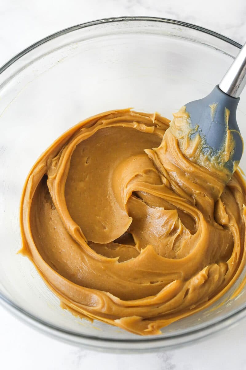 Stirring peanut butter in a glass bowl