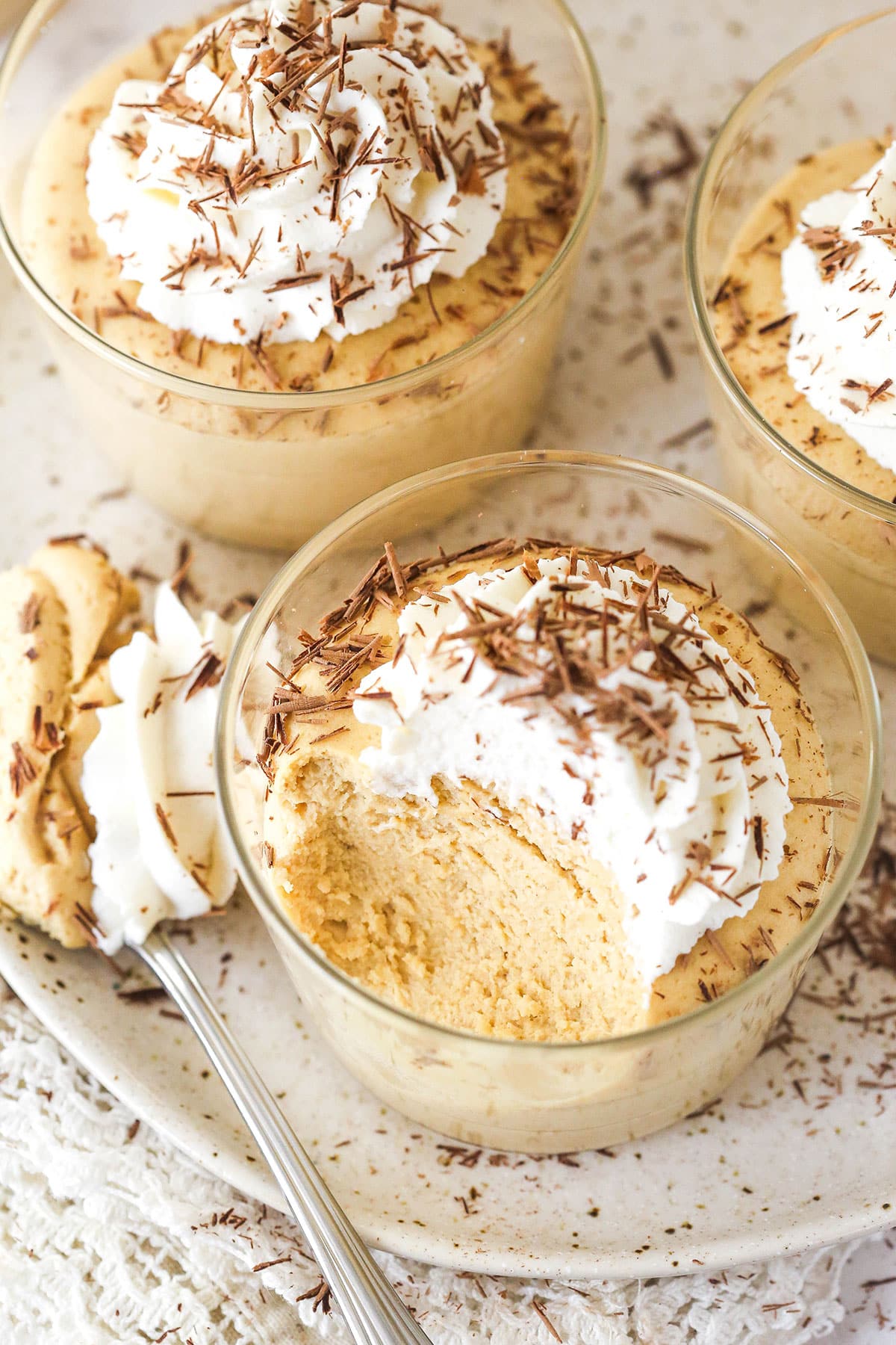 Overhead view of cups of peanut butter mousse, one with a few bites missing