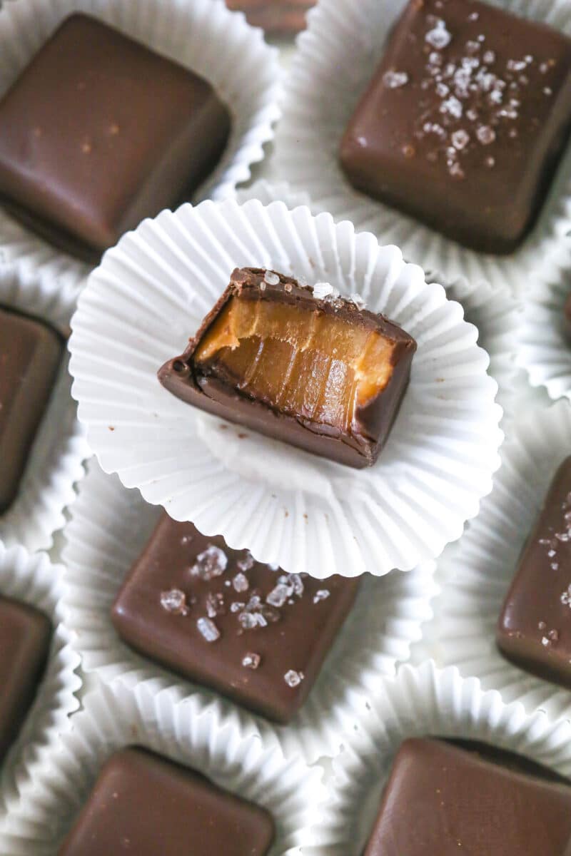 chocolate covered caramels in little papers with a bite taken out of one