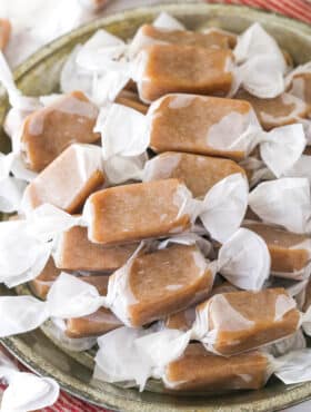 homemade caramels wrapped in wax paper in grey dish