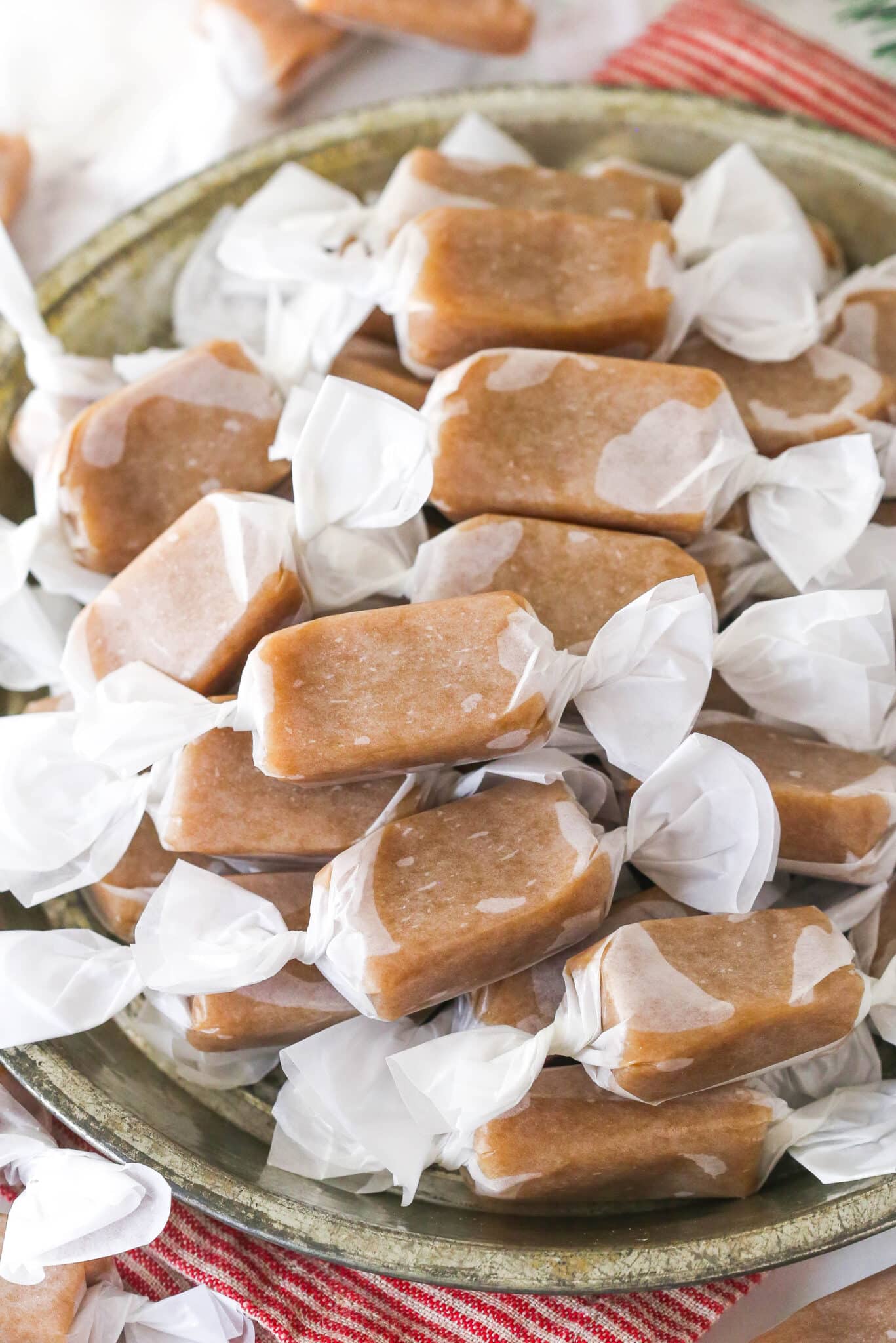 homemade caramels wrapped in wax paper in grey dish