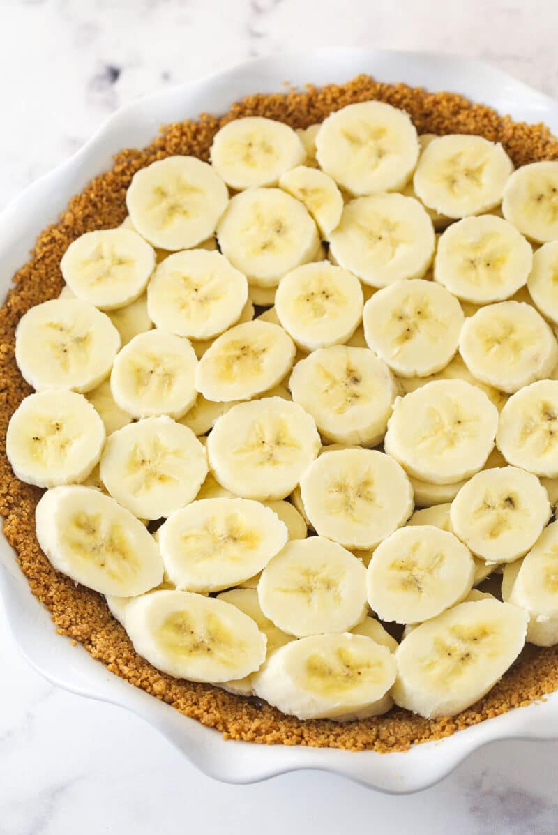 Banana slices on top of toffee filling in a graham cracker crust