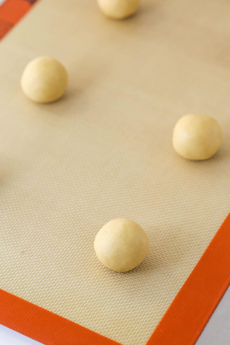 Balls of sugar cookie dough on a baking sheet