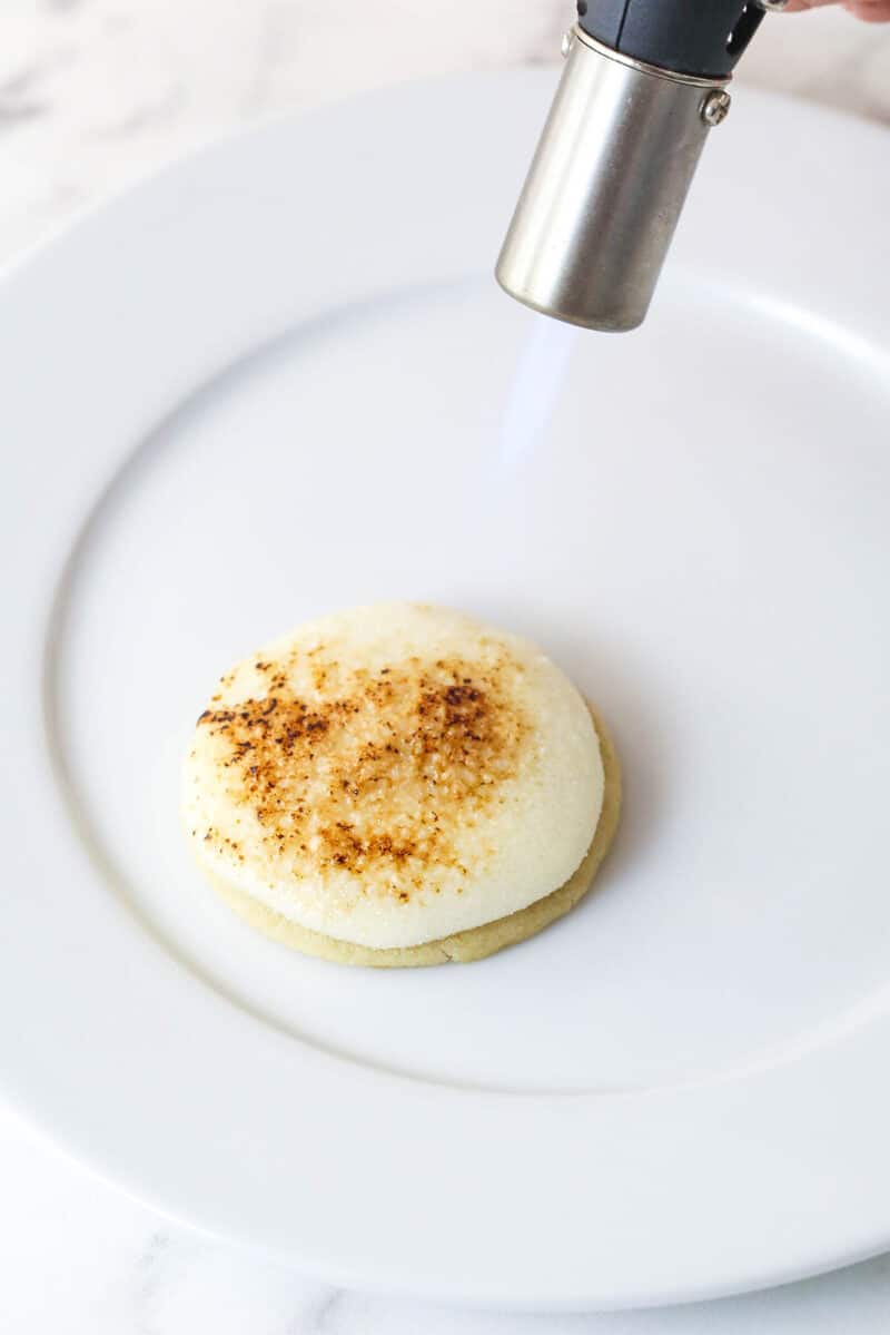 Torching the top of a creme brulee cookie on a plate