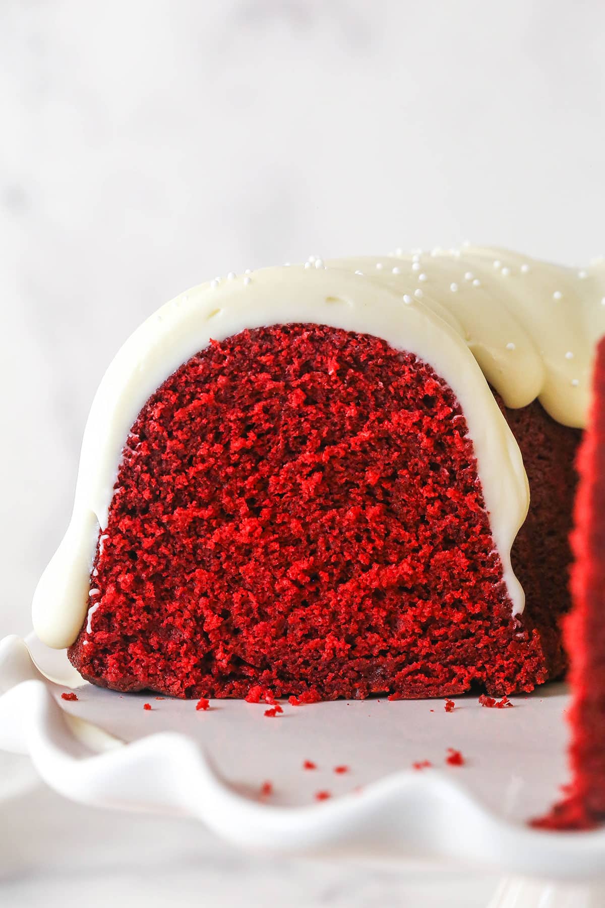 The front of a red velvet bundt cake on a white plate