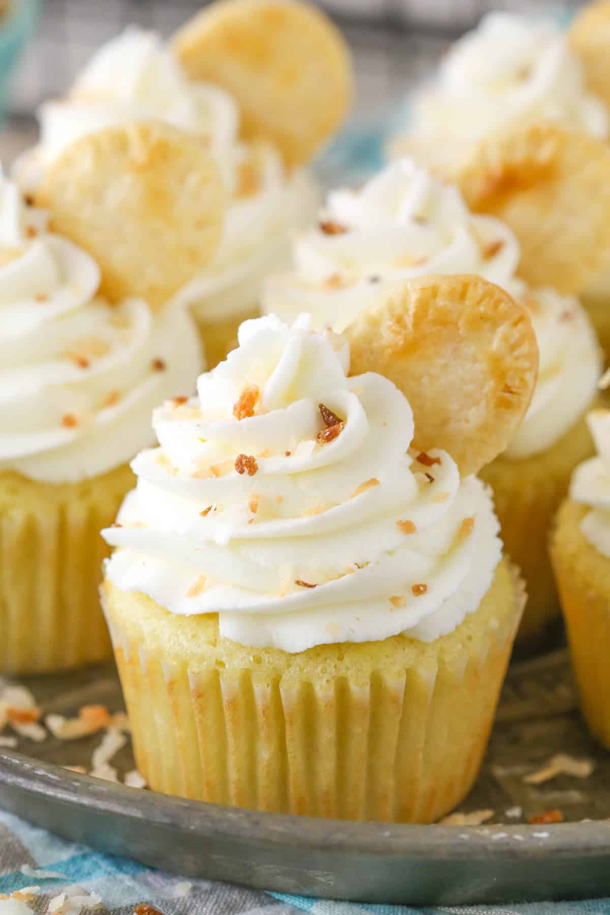 Close up of coconut cream pie cupcakes on a metal tray.