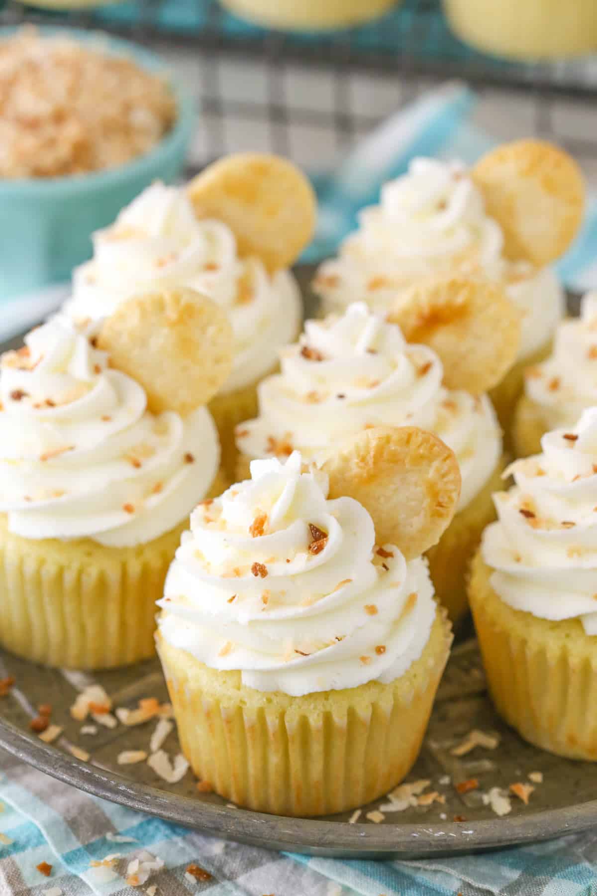 Several coconut cream pie cupcakes on a metal tray.